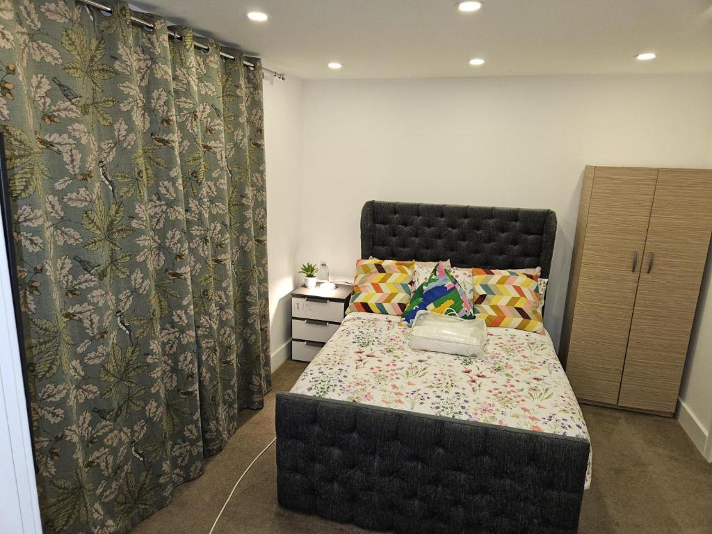 伦敦London Glamour Apartments的一间卧室配有一张带黑色床头板和窗帘的床