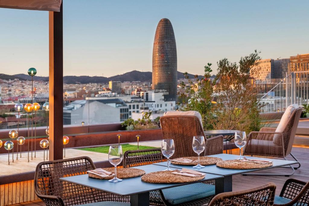 巴塞罗那佩雷四世萨勒酒店的一张带酒杯的桌子,享有城市美景