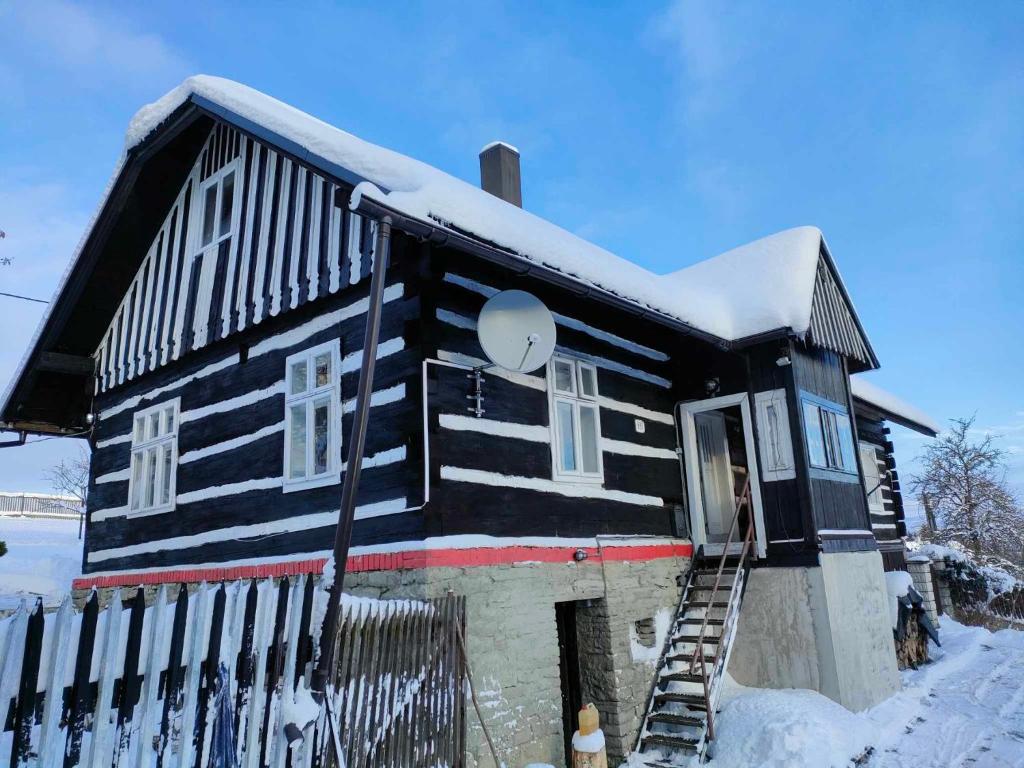 ČierneHorská Roubenka Emma的一座黑白房子,里面积雪