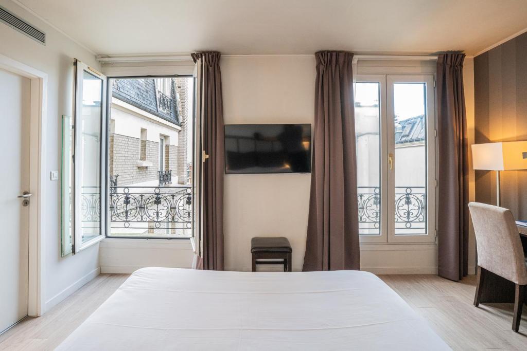 巴黎Hotel de Flore - Montmartre的酒店客房设有床和窗户。