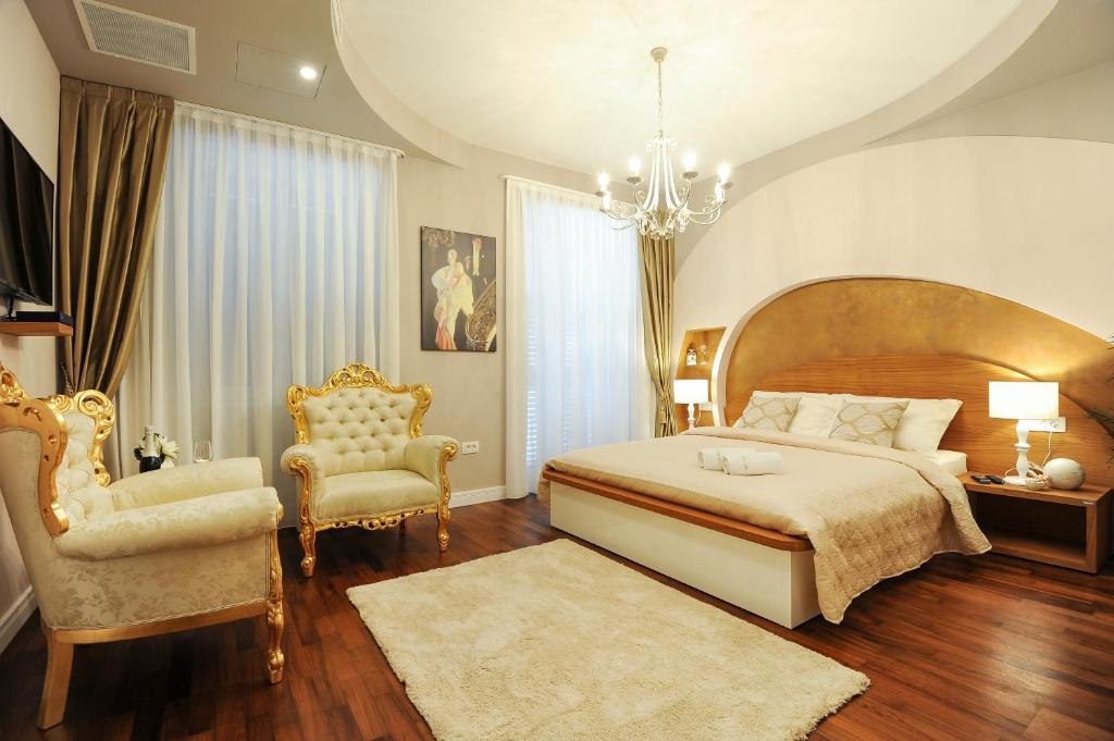 扎达尔金与银豪华旅馆的一间卧室配有一张大床和两把椅子