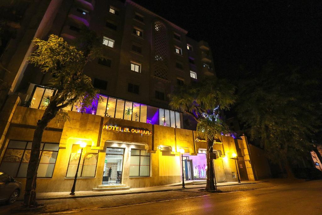 突尼斯El Oumara Hotel的街上的一座建筑,晚上有灯
