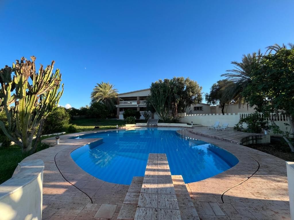 阿加迪尔Tiguimi Vacances - Oasis Villas, cadre naturel et vue montagne的庭院里的一个蓝色海水游泳池