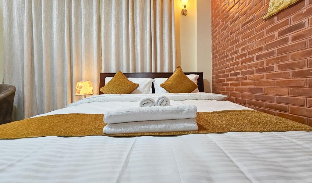帕坦Badri Homes的卧室配有白色床和毛巾