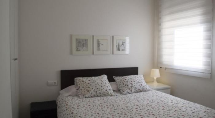 巴塞罗那康德古尔公寓式酒店的一间卧室配有带两个枕头的床和窗户