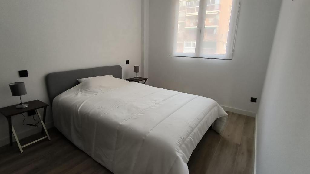 马德里Exyca Metropolitano的白色的卧室设有床和窗户