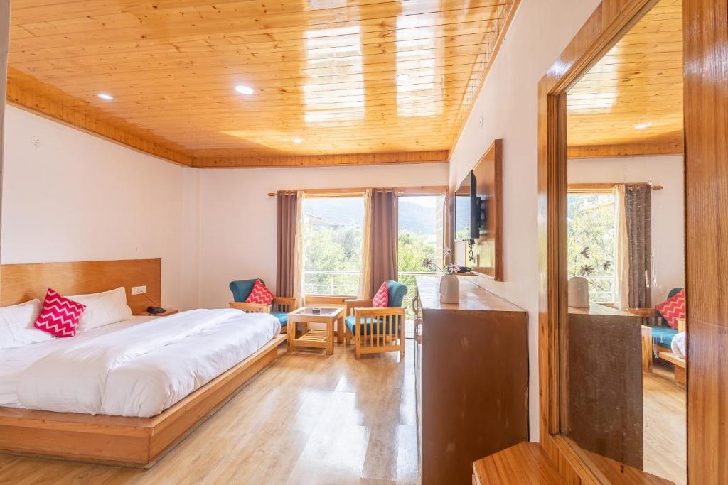 马拉里Aroha Residency- A Countryside Resort的卧室配有一张床、一张桌子和椅子