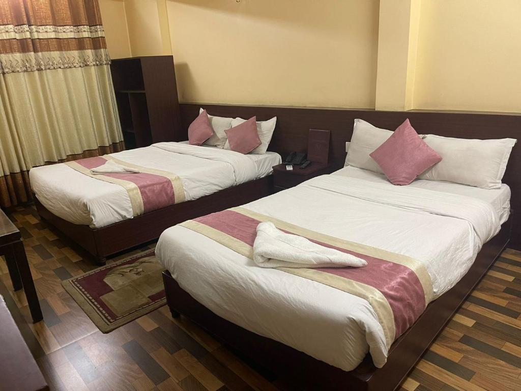加德满都Rameshworam Hotel的两张位于酒店客房的床,配有粉红色枕头