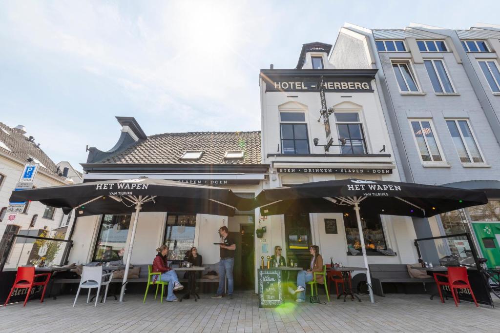 蒂尔堡蒂尔堡赫伯格海特瓦本婉酒店的一间咖啡馆,人们坐在大楼前的桌子旁