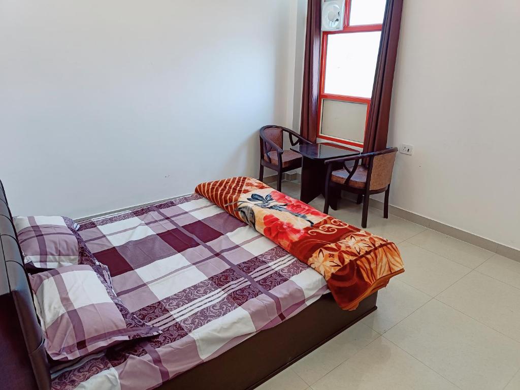 RajDarbar的一间卧室配有一张床、一张桌子和一个窗户。