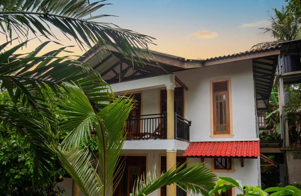 阿杭格默Manel Villa的带阳台和棕榈树的白色房屋