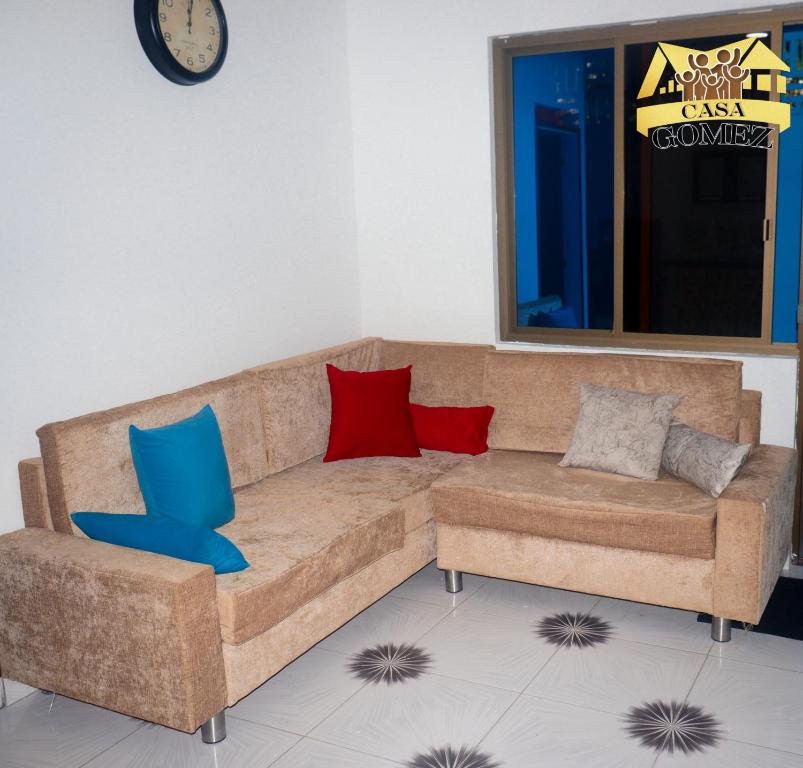 莱蒂西亚Casa Gomez Apto 2的客厅配有棕色沙发,提供红色和蓝色枕头