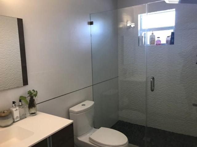 基拉戈Twice the Charm的一间带卫生间和玻璃淋浴间的浴室