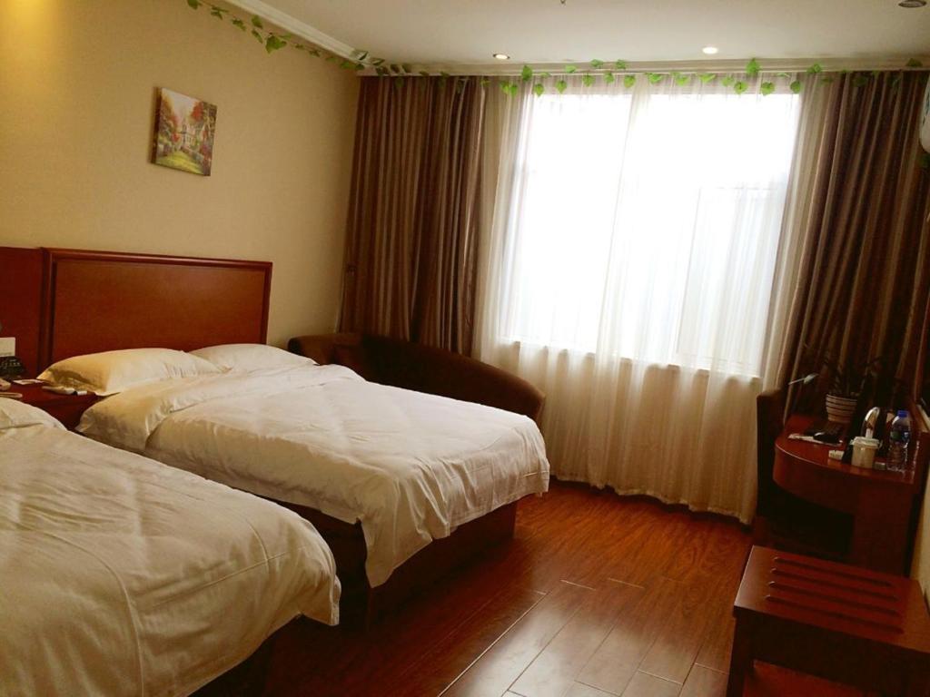 涡阳格林豪泰涡阳胜利路阜阳商厦快捷酒店的酒店客房设有两张床和窗户。