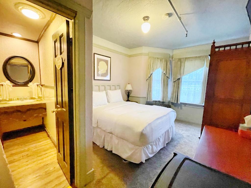 朱诺阿拉斯加酒店及酒吧的卧室配有白色的床和镜子