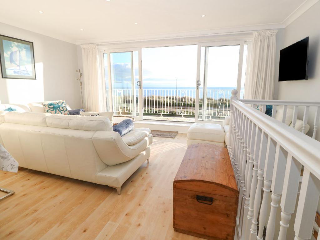 普尔赫利The Beach House的客厅配有白色家具和大窗户
