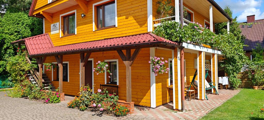 苏普拉希尔pokoje wypoczynkowe "Róża"的红色屋顶的黄色小房子