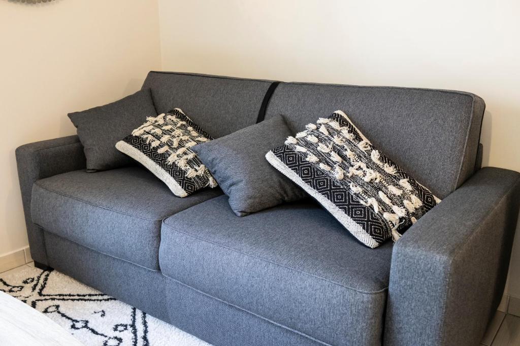 布西圣乔治Charmant studio en résidence avec parking的蓝色的沙发,配有两个枕头