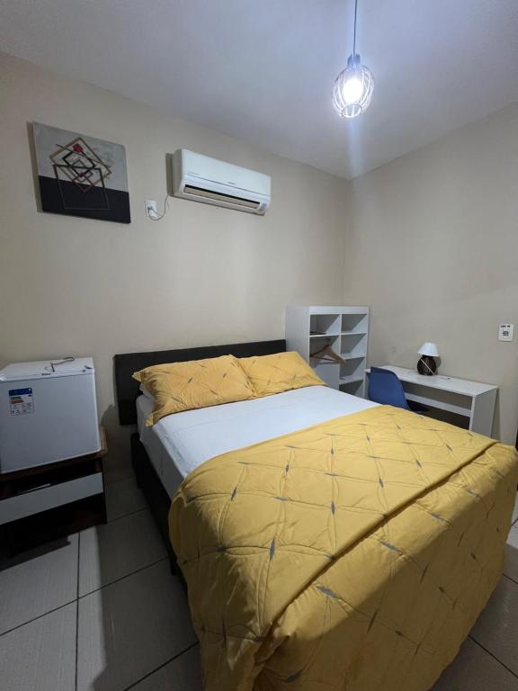巴拉奈里奥-坎布里乌Pousada Riosmar的一间卧室配有一张黄色棉被的床