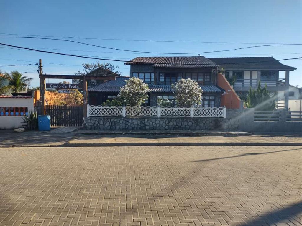 圣佩德罗-达阿尔德亚Pousada Canto da Praia的街道前有白色围栏的房子