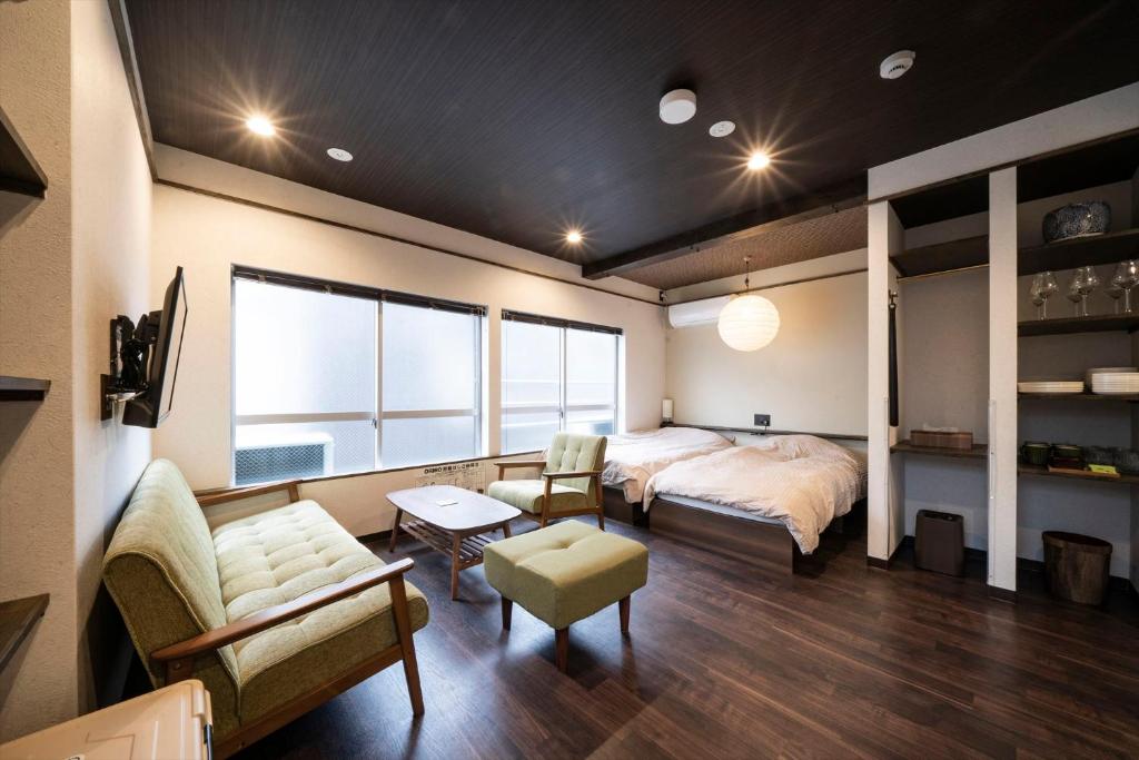 神户かゑる屋的一间卧室配有一张床、一张沙发和一张桌子