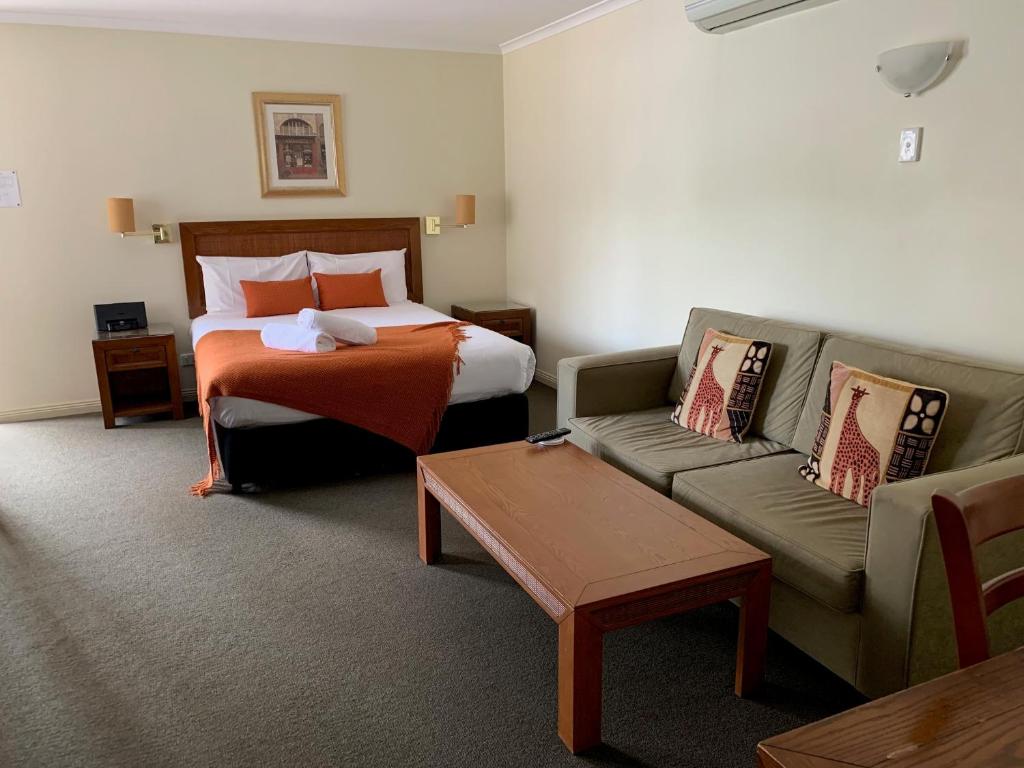 阿米代尔阿米代尔松树汽车旅馆的酒店客房,配有床和沙发