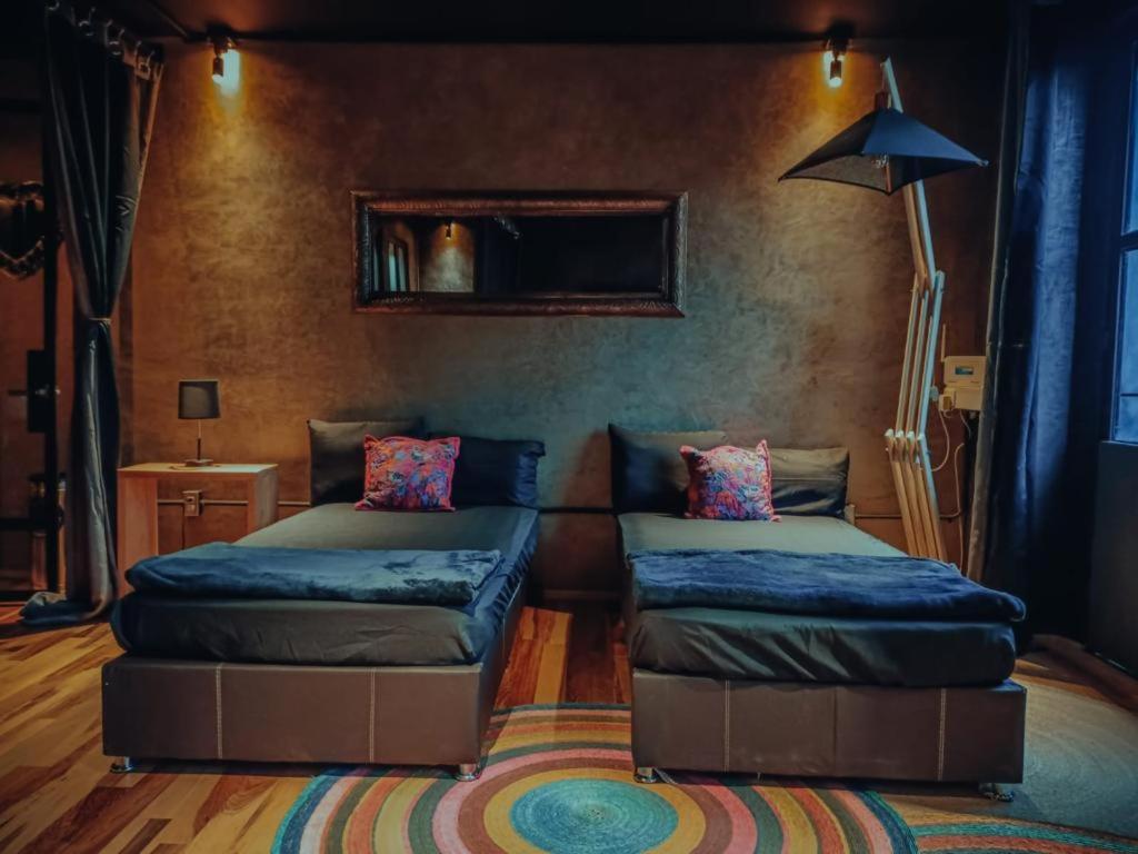 墨西哥城Casa Sabina Down Town Mexico City的一间带两张床和一张沙发的客厅