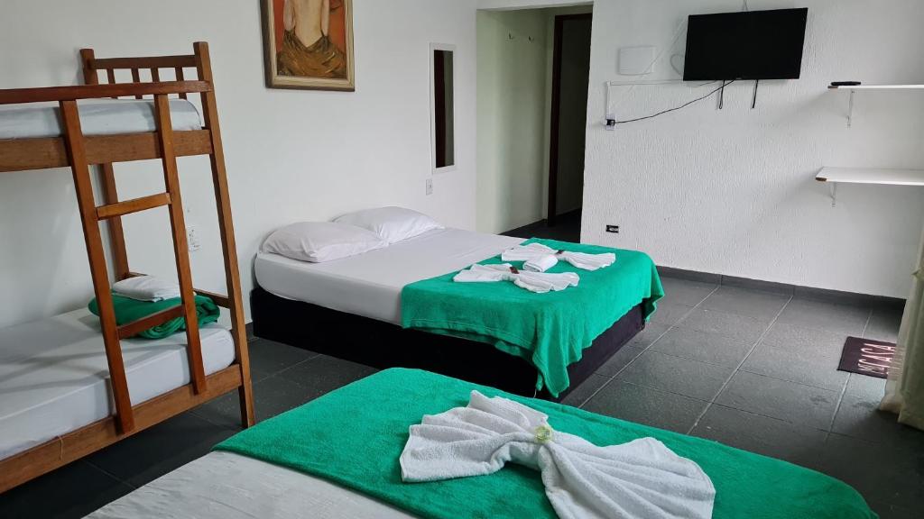 佩鲁伊比Porto Suítes Peruíbe的客房设有两张双层床和电视。