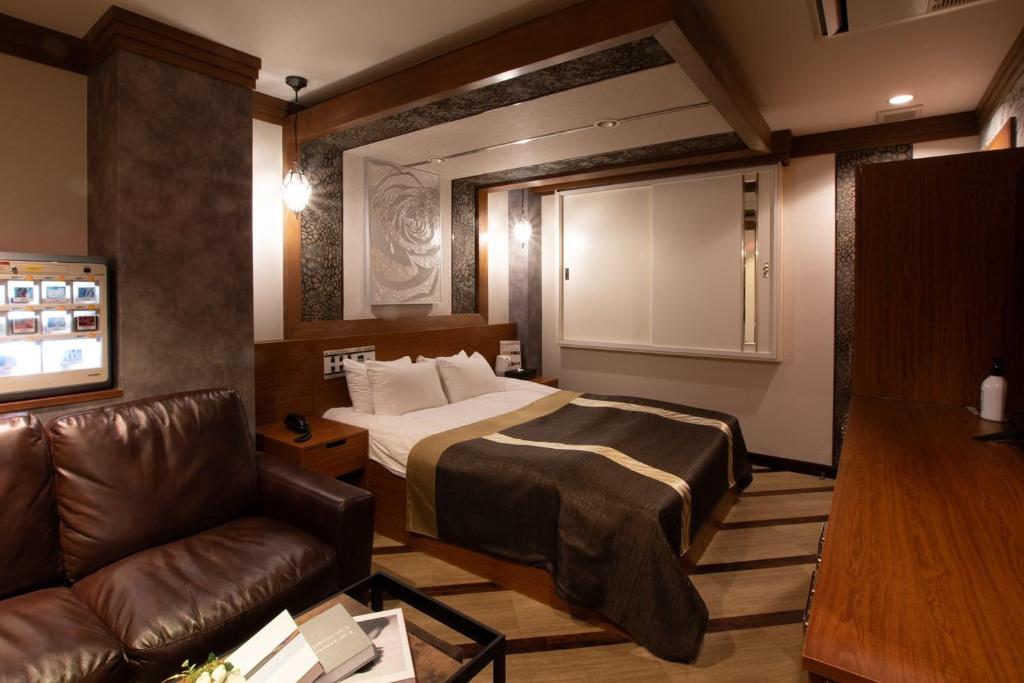 松户市HOTEL KSEA (Adult Only)的酒店客房,配有床和沙发