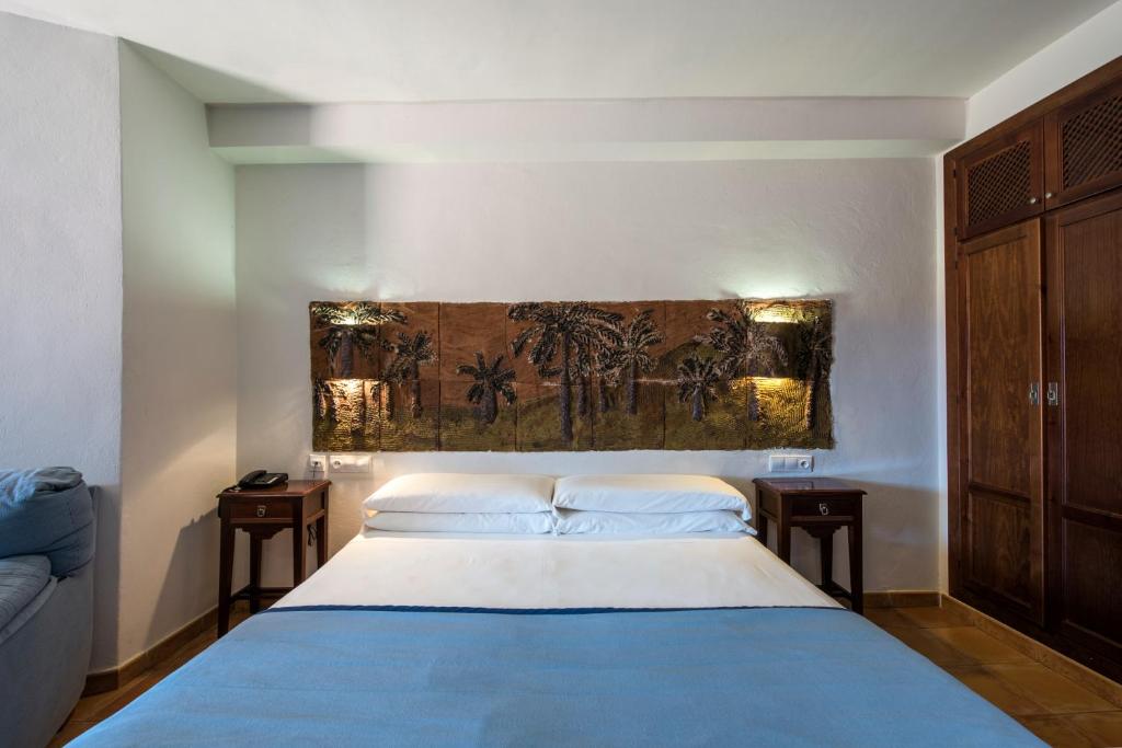 厄尔·坎皮洛·德·罗达尔罗达尔基拉尔自然酒店与卡波德加塔水疗中心的一间卧室配有蓝色的床和2个床头柜
