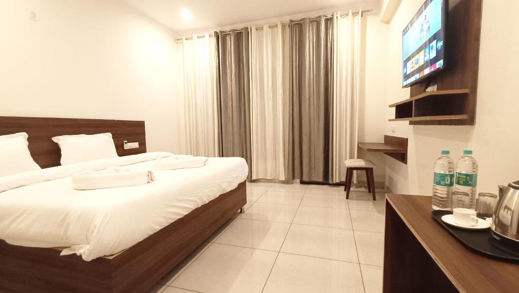 瑞诗凯诗Hotel Tapovanam Rishikesh的酒店客房,配有床和电视