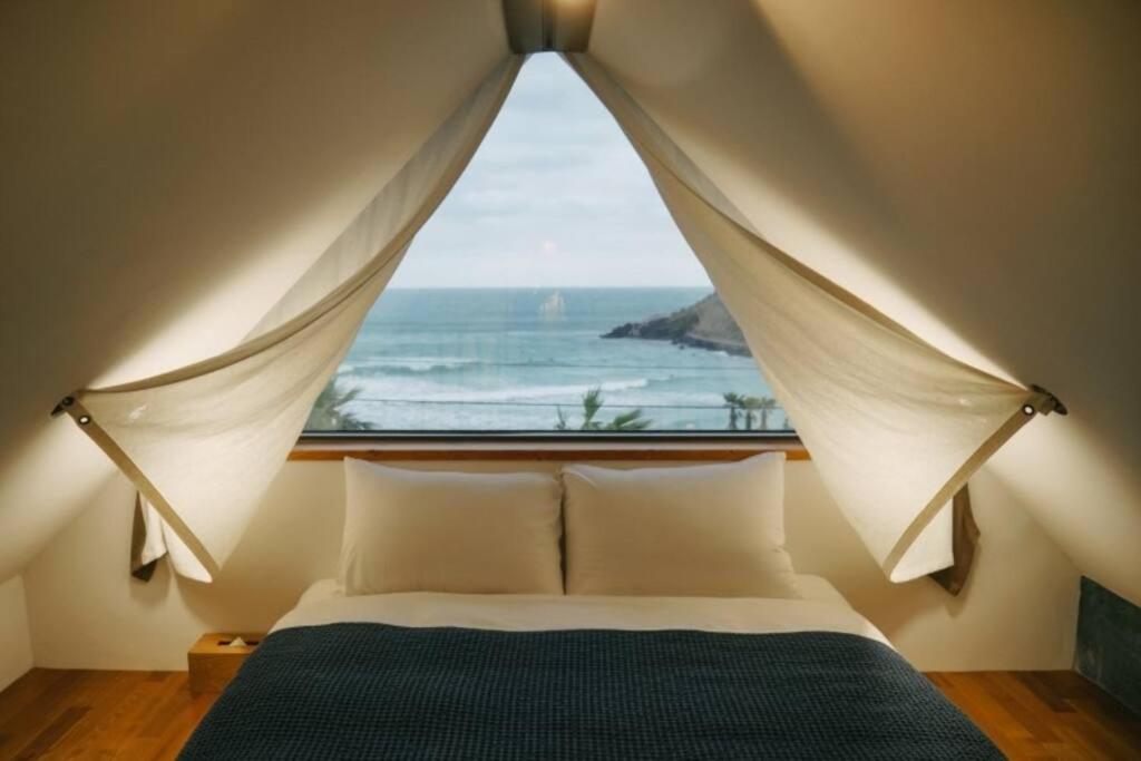 济州市Yaho Beach House的一间卧室设有一张大床和大窗户