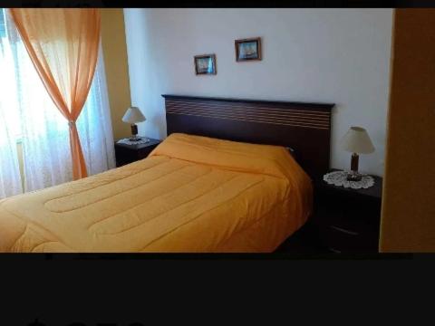 米拉玛Alquiló Casa Miramar temporada 2024的一间卧室配有一张床和两个带灯的床头柜