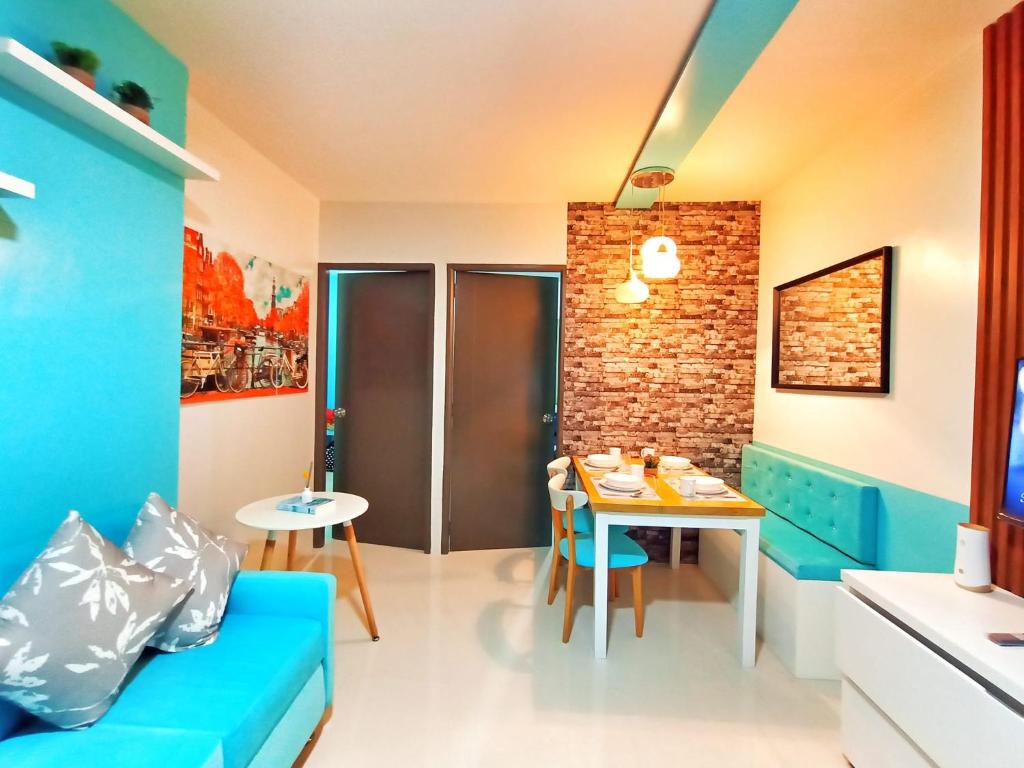 公主港Palawan Paradise Condotel 1L的客厅配有蓝色的沙发和桌子