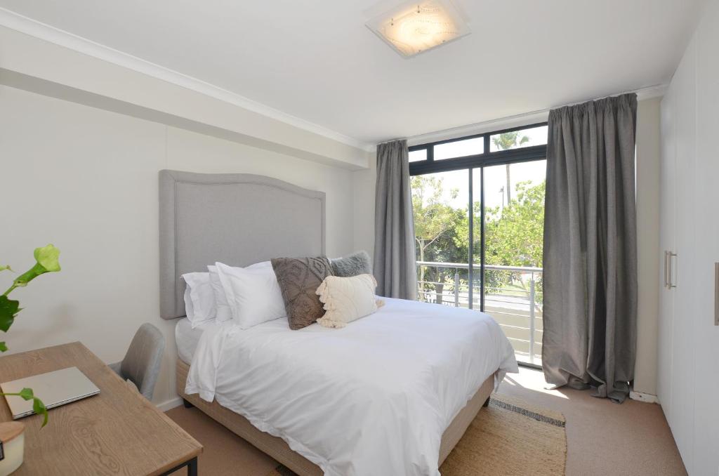 开普敦Apartment in Century City的一间卧室设有一张床和一个大窗户
