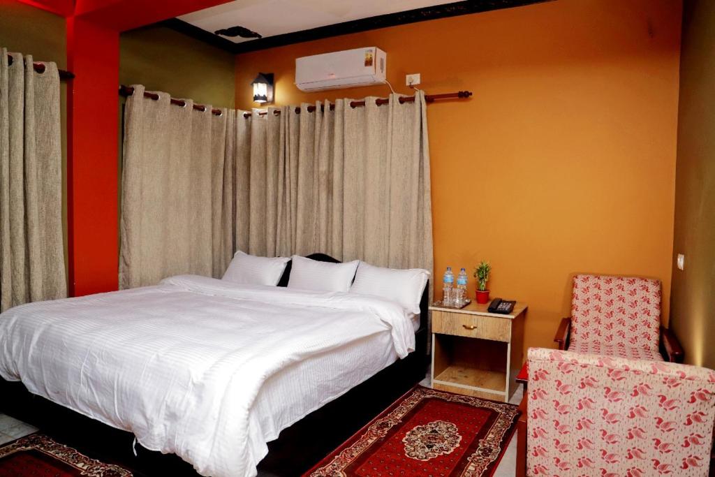奇旺Hotel Park Treasure的卧室配有白色的床和椅子