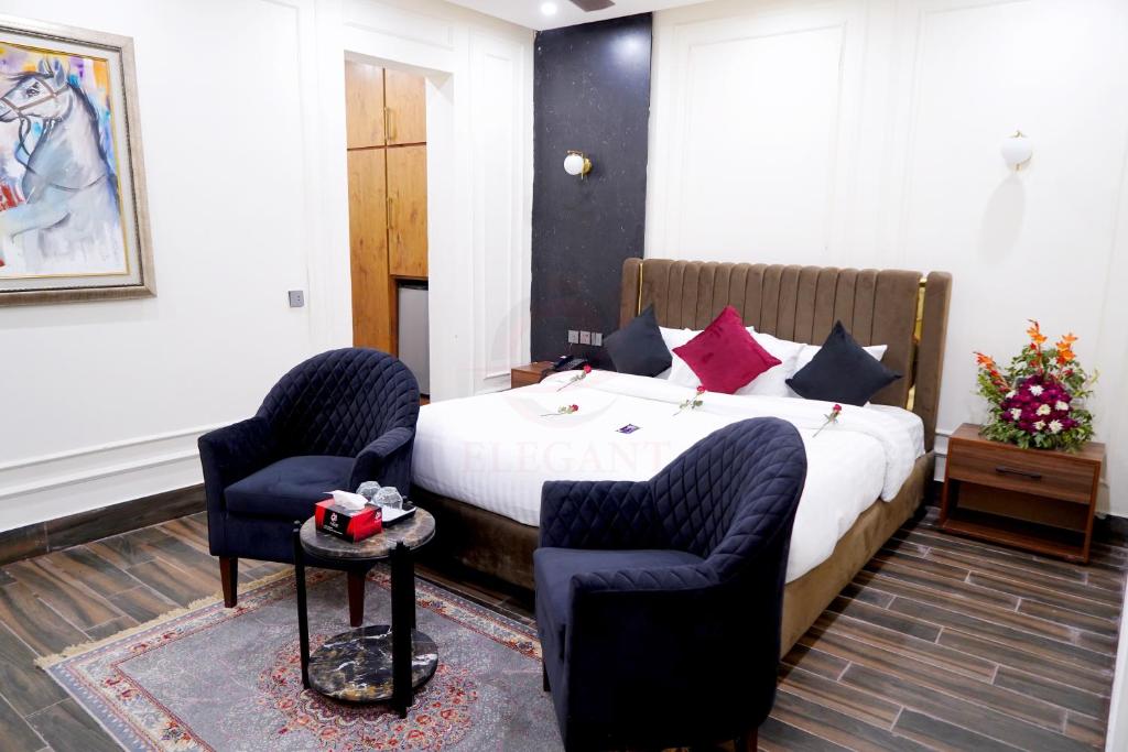 木尔坦Elegant Executive Suite的酒店客房,配有一张床和两把椅子