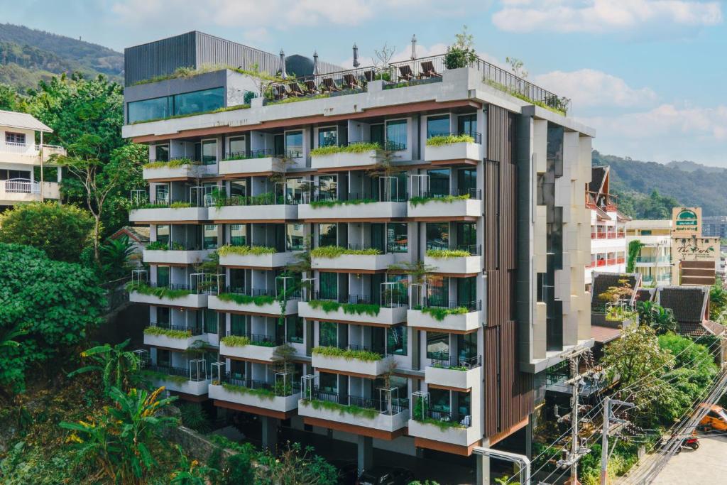 芭东海滩Rak Elegant Hotel Patong - SHA Extra Plus的公寓大楼的阳台种植了植物