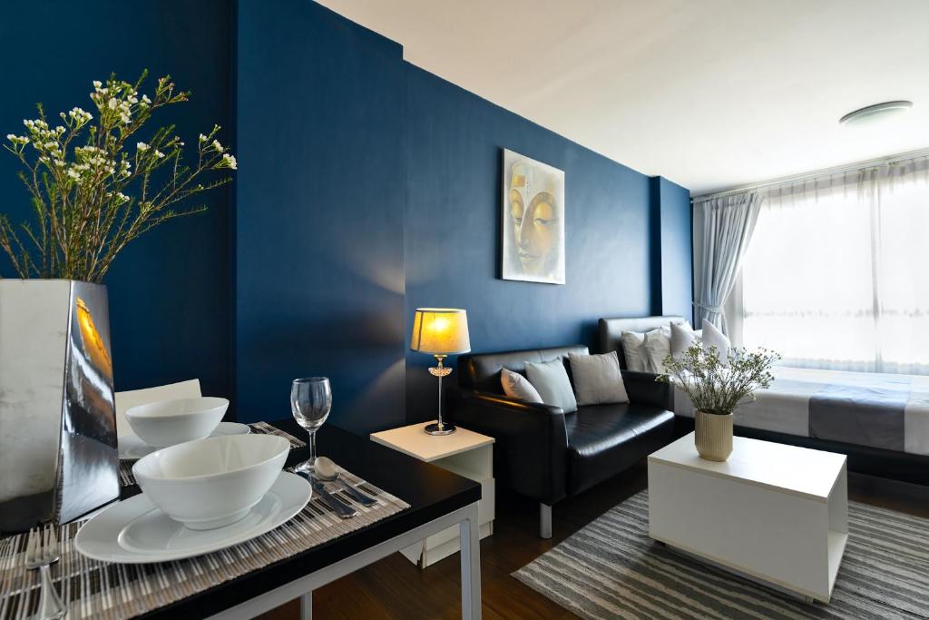 华欣First Choice Suites SHA Plus Extra的客厅拥有蓝色的墙壁和沙发