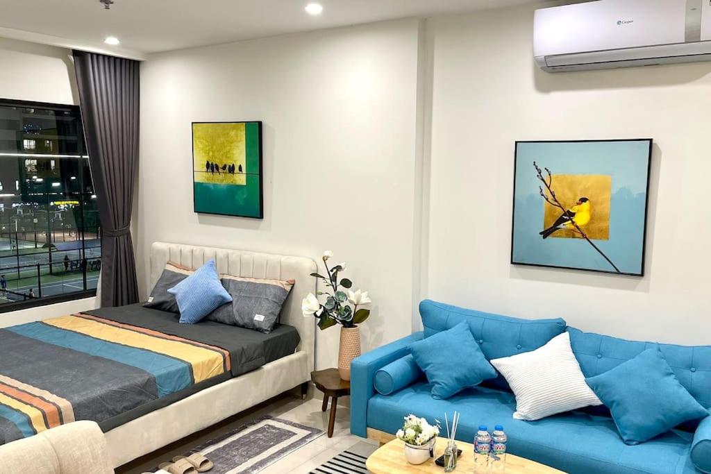 河内Vinhomes Smart City - Căn hộ đẹp, sang trọng tại tòa nhà S1.02的一间卧室配有一张床和一张蓝色的沙发