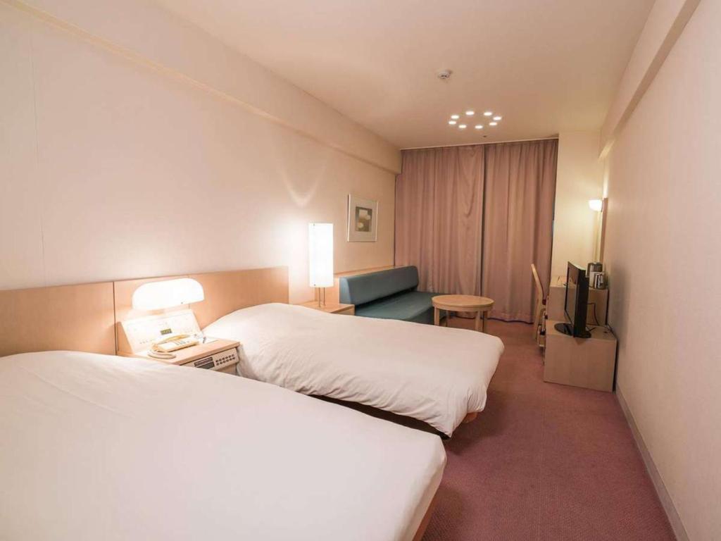 汤泽町苗场王子大饭店的酒店客房设有两张床和电视。