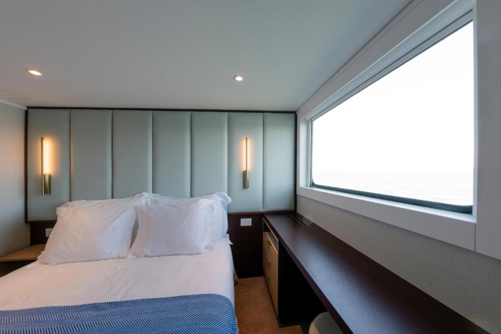 阿威罗Costa do Sal Hotel Boat Lounge的一间卧室设有一张床和一个大窗户