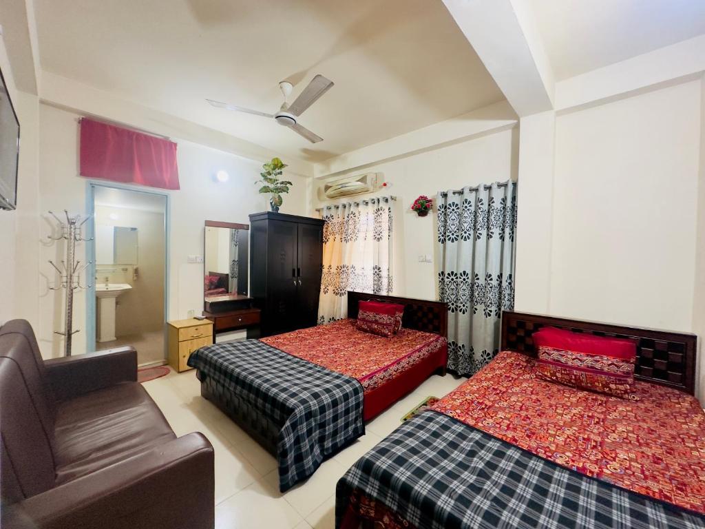 达卡Appayan Guest House Baridhara (Bhagyakula Building)的一间带两张床和一张沙发的卧室