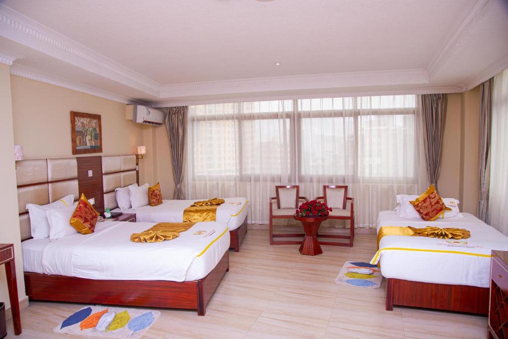 达累斯萨拉姆Tiffany Diamond Hotels Ltd - Indira Gandhi street的酒店客房设有三张床和窗户。