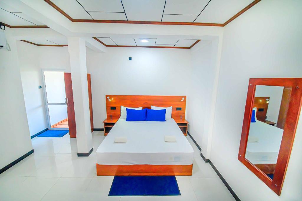 阿鲁特伽马Apartments by Tyzon的一间卧室配有一张带蓝色枕头和镜子的床