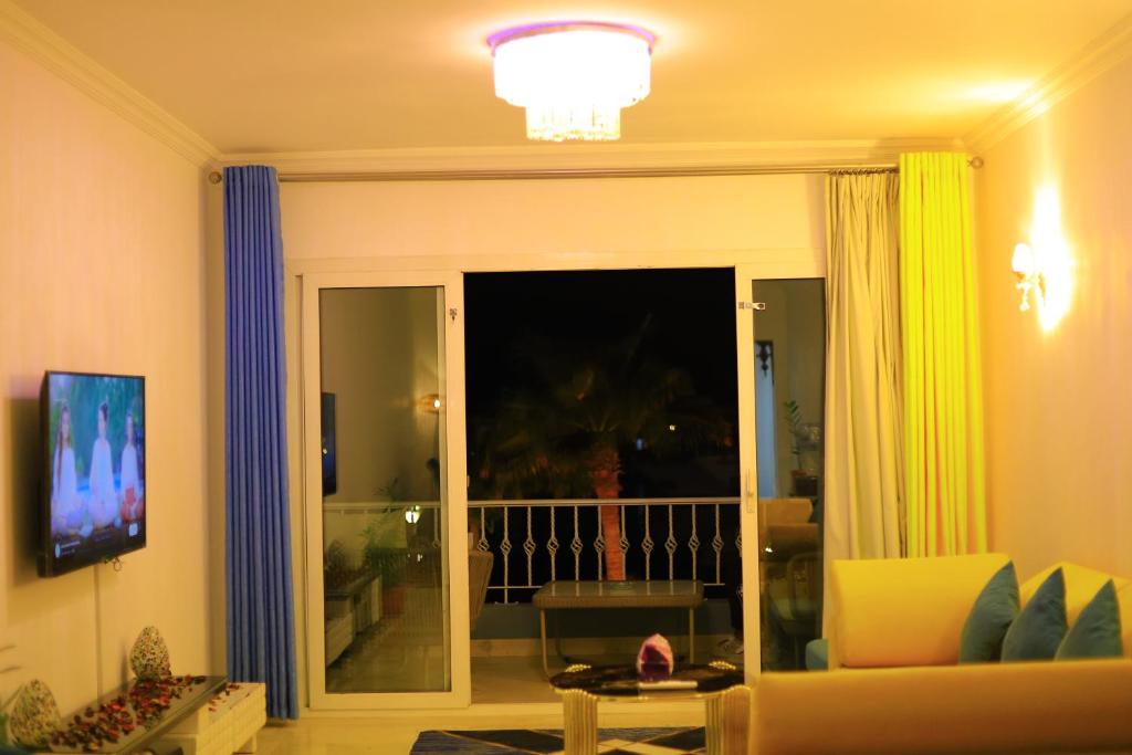 赫尔格达New Marina Hurghada Suite的客厅设有滑动玻璃门,通往阳台