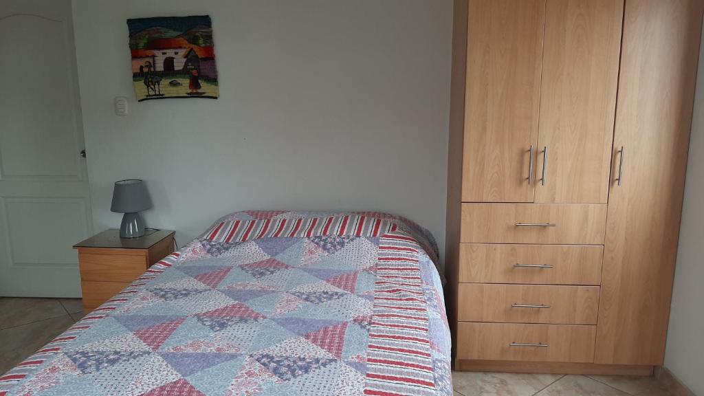 利马Terraza más habitaciones en La Molina的一间卧室配有一张床和一个木制橱柜