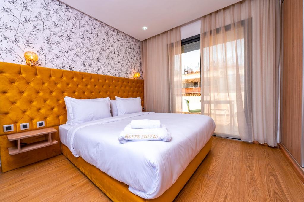 卡萨布兰卡Maarif Elite Suites的一间卧室设有一张大床和一个大窗户