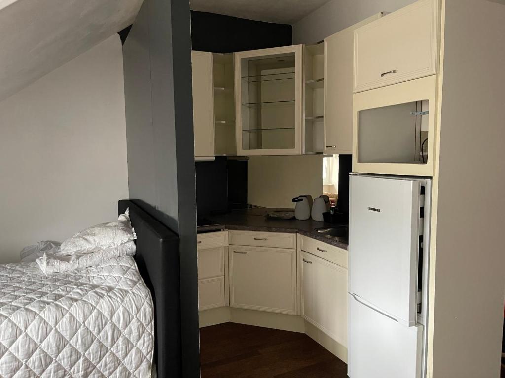 MaasbreeB&B Santorini的小厨房配有白色橱柜和白色冰箱