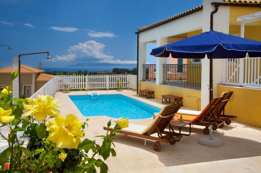 卡拉瓦杜斯Villa Karavisianikos Faros的一个带游泳池和遮阳伞的庭院